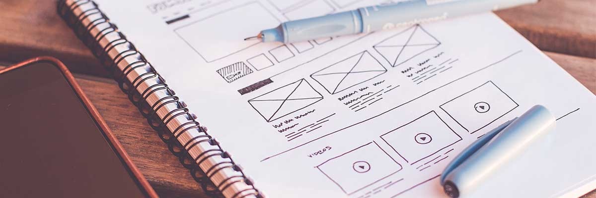 Notepad with wireframes and UX elements drawn